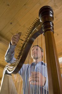 Instrumentenpflege - Peter Mürnseer stimmt Harfe